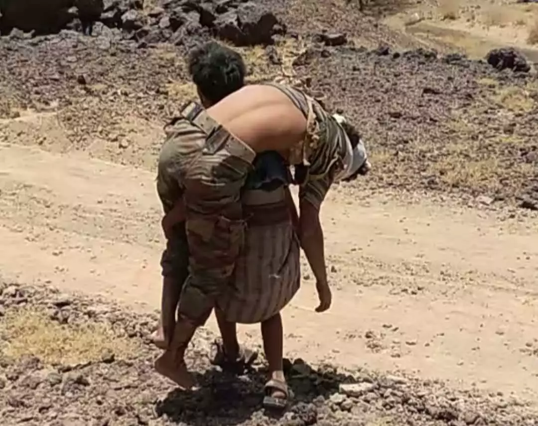 شاهد احد افراد الجيش يحمل جريح حوثي على أكتافه في مأرب يشعل مواقع التواصل ( صورة )
