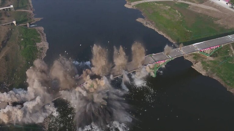 خلال 10ثوانٍ فقط .. شاهد لحظة تفجير جسر عملاق للسيارات يطل على نهر عميق (فيديو)
